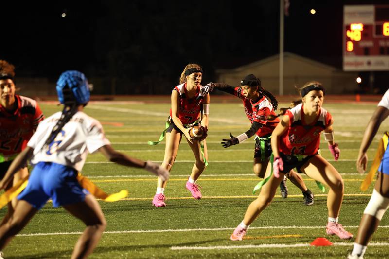 Bradley-Bourbonnais' Elise Munsterman, center, fakes a handoff to Nevaeh Brown during the Boilermakers' 60-7 victory over Joliet Central in the season opener on Aug. 25, 2025.