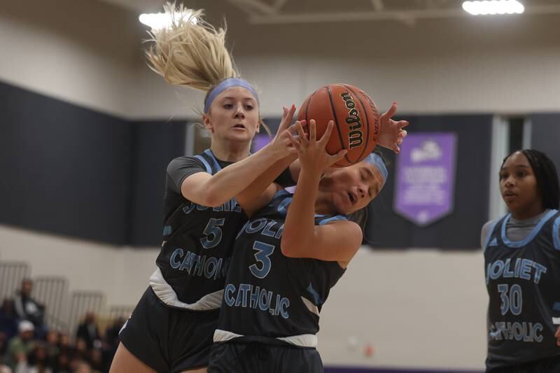 Joliet Catholic’s Ingrid Troha (5) and Elena Czerkies (3) collide going for the rebound against Joliet West in the WJOL Basketball Tournament at Joliet Junior College Event Center on Monday