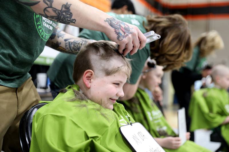 Aiden Ryan, 7, has his head shaved by Dan Forni during the St. Charles Challenge fundraiser for the St. Baldrick’s Foundation on Friday, March 15, 2024 at St. Charles East High School.