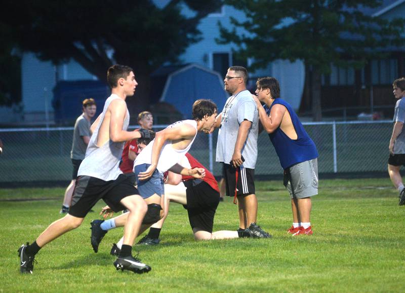 Forreston football Coach Keynon Janicke (center) watches his players during a scrimmage on the Cardinals football field on Thursday, July 27.