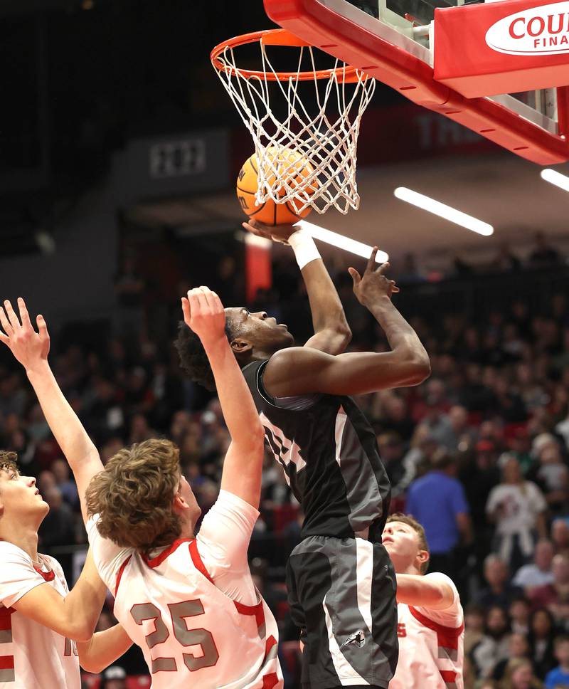 Kaneland's Jeffrey Hassan gets up a shot between three Morton defenders Monday, March 9, 2026, during their IHSA Class 3A supersectional matchup in the Convocation Center at Northern Illinois University in DeKalb.
