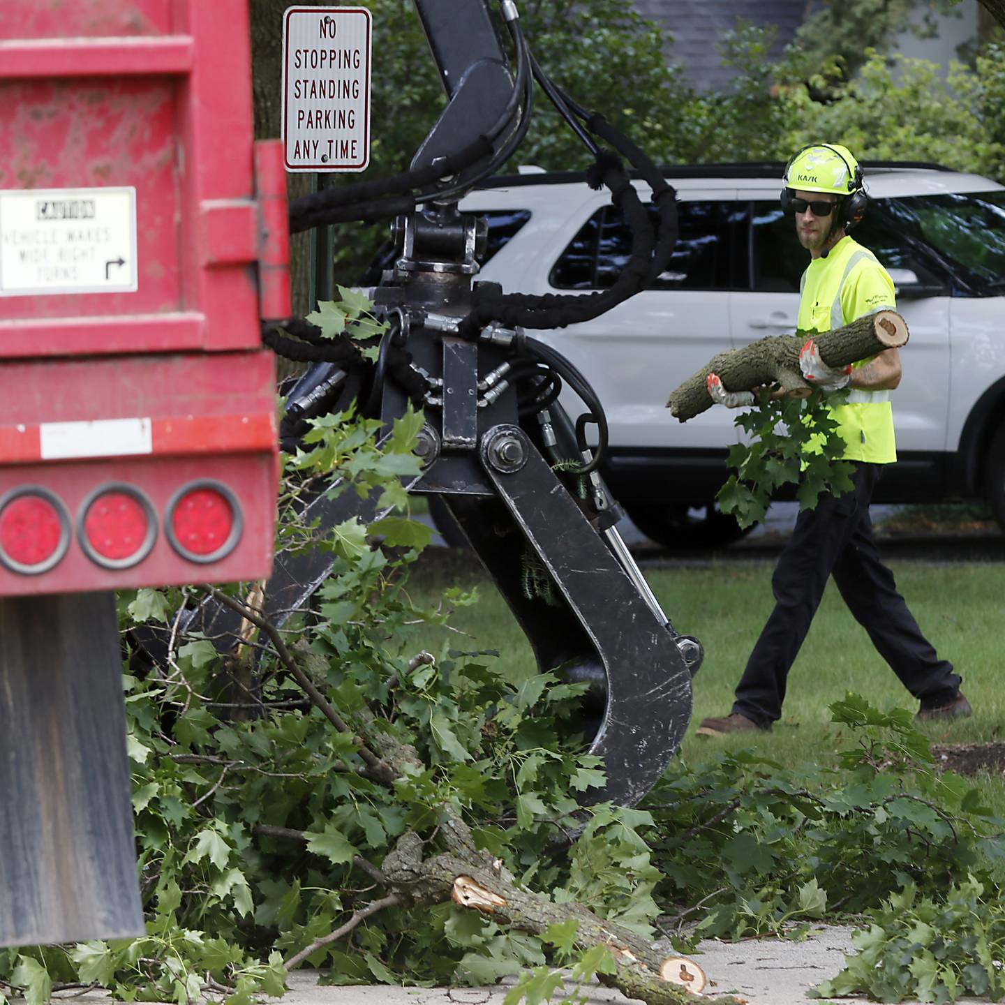 A worker for the Crystal Lake Department of Public Works removes storm debris near the intersection of Golf Road and Highland Avenue on Tuesday, July 16, 2024, after McHenry County was hit by its third night of severe thunderstorms.