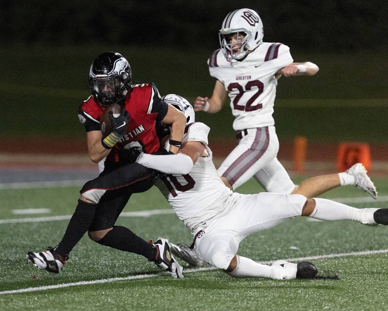 Aurora Christian's Dom Klimpke makes the one handed catch as Wheaton Academy's Logan Oros makes the tackle on Friday, Oct. 17,2025 in Aurora.