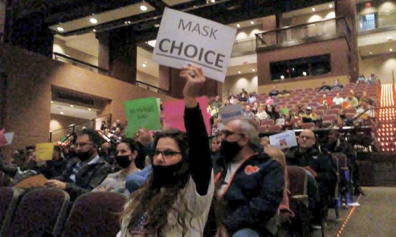 Dawn Schindler of Oswego, center, lets her sign express her opinion at the Feb. 10, 2022 Oswego School District Board meeting. (Mark Foster - mfoster@shawmedia.com)