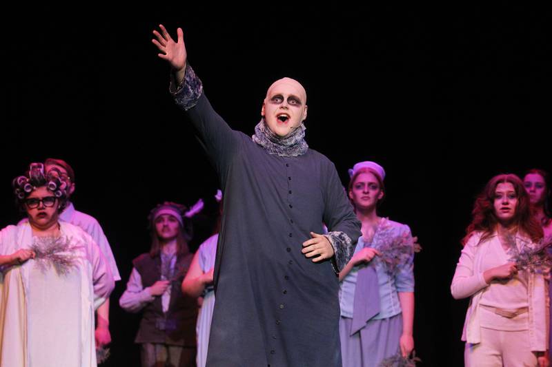 Michael Sligting, 18, of Fox Lake (Uncle Fester) sings a song called "But Love," with the cast (Ancestors) during dress rehearsal April 18 for the spring musical, "The Addams Family" at Grant Community High School in Fox Lake.