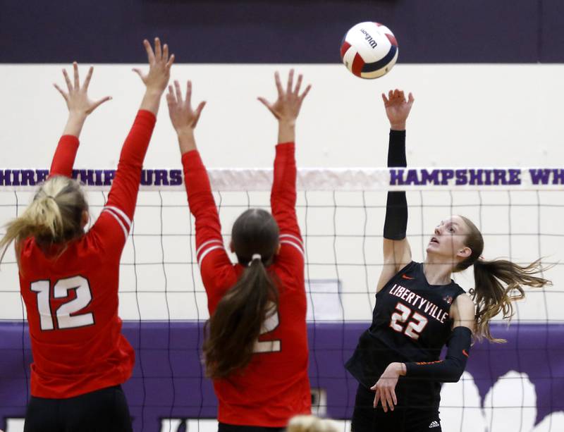 Libertyville's Emerson Zovistoski (right) hits the ball into the block of Huntley's Summer Massow (left) and achael Hein (center) during an IHSA Class 4A Hampshire Sectional semifinal volleyball match on Tuesday, Nov. 4, 2025, at Hampshire High School.