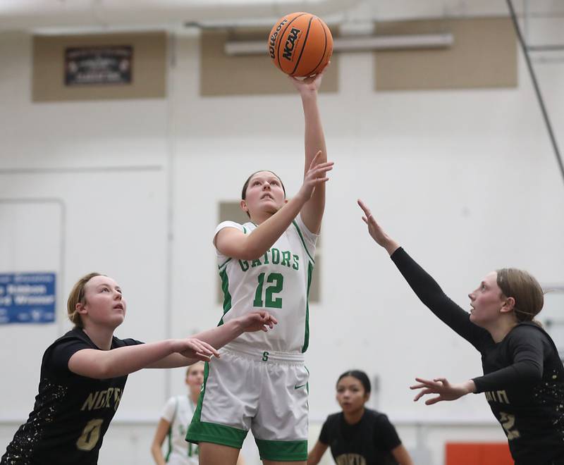Crystal Lake South's Gaby Dzik shoots the ball between Grayslake North's Jane Pritchard (left) and Ashlyn Stoneham (right) during a Northern Illinois Holiday Classic semifinal girl basketball game on Tuesday, Dec. 16, 2025, at McHenry High School.