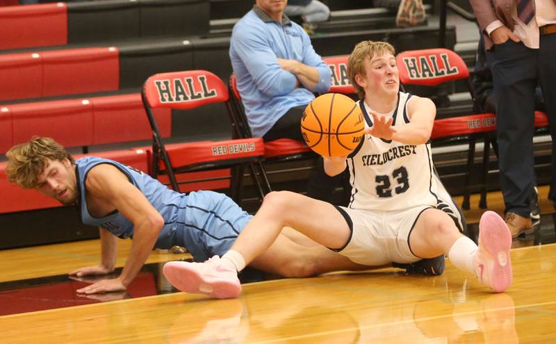 Fieldcrest's Jordan Heider tosses the ball to a teammate while saving it from going out of bounce as Bureau Valley's Landon Hulsing dives late to the ball during the 50th annual Colmone Classic on Monday, Dec. 9, 2024 at Hall High School.