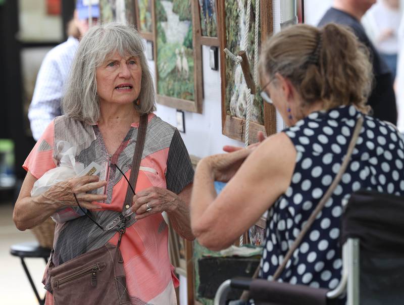 Susan Borghesi, from Naperville, talks to artist Anna Repke, from Chillicothe, Saturday, July 26, 2025, during the Geneva Arts Fair in downtown Geneva.