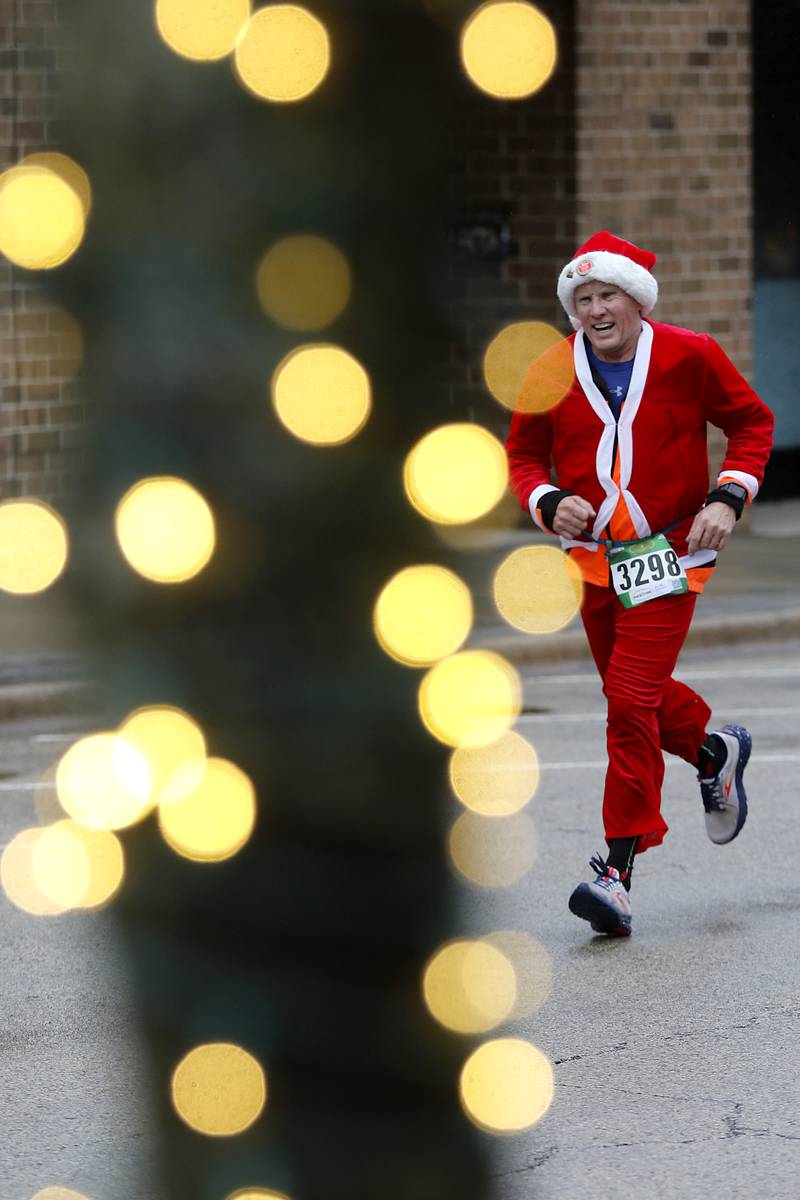 David Manikowski runs to the finish line during the McHenry County Santa Run For Kids on Sunday morning, Dec. 3, 2023, in Downtown Crystal Lake. The annual event raises money for agencies in our county who work with children in need.