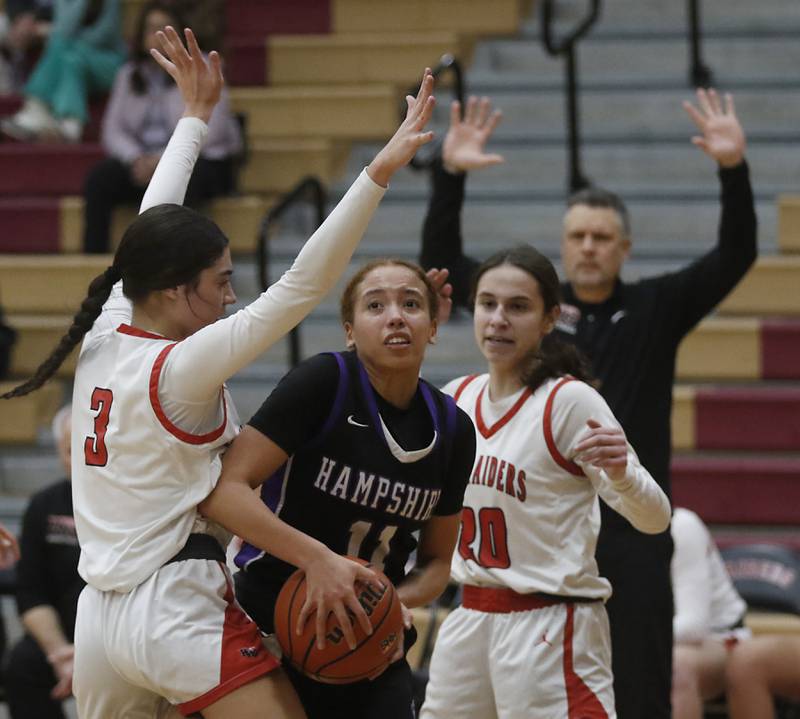 Hampshire's Mikala Amegasse tries to drive to the basket against Huntley's Cassidy Serpe (left)  and Alyssa Borzych (right) during a Fox Valley Conference girls basketball game Wednesday, Jan. 24, 2024, at Huntley High School.