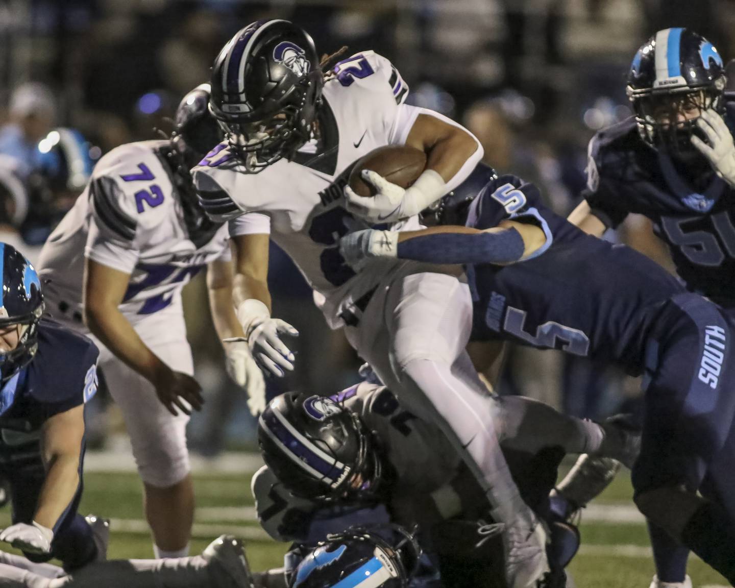 Downers Grove North's Kevin Jay Jr. (27) fights for extra yards during football game between Downers Grove North at Downers Grove South Friday, Sept 5, 2025  in Downers Grove.