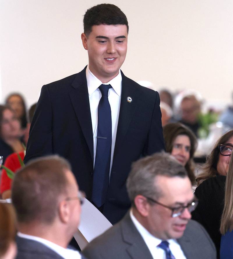 Andrew Miller, branch manager at Old National Bank, comes up to accept the Outstanding Business Award on behalf of the bank Thursday, March 5, 2026, during the Sycamore Chamber of Commerce Annual Meeting in Memorial Hall at St. Mary's Catholic Church in Sycamore.
