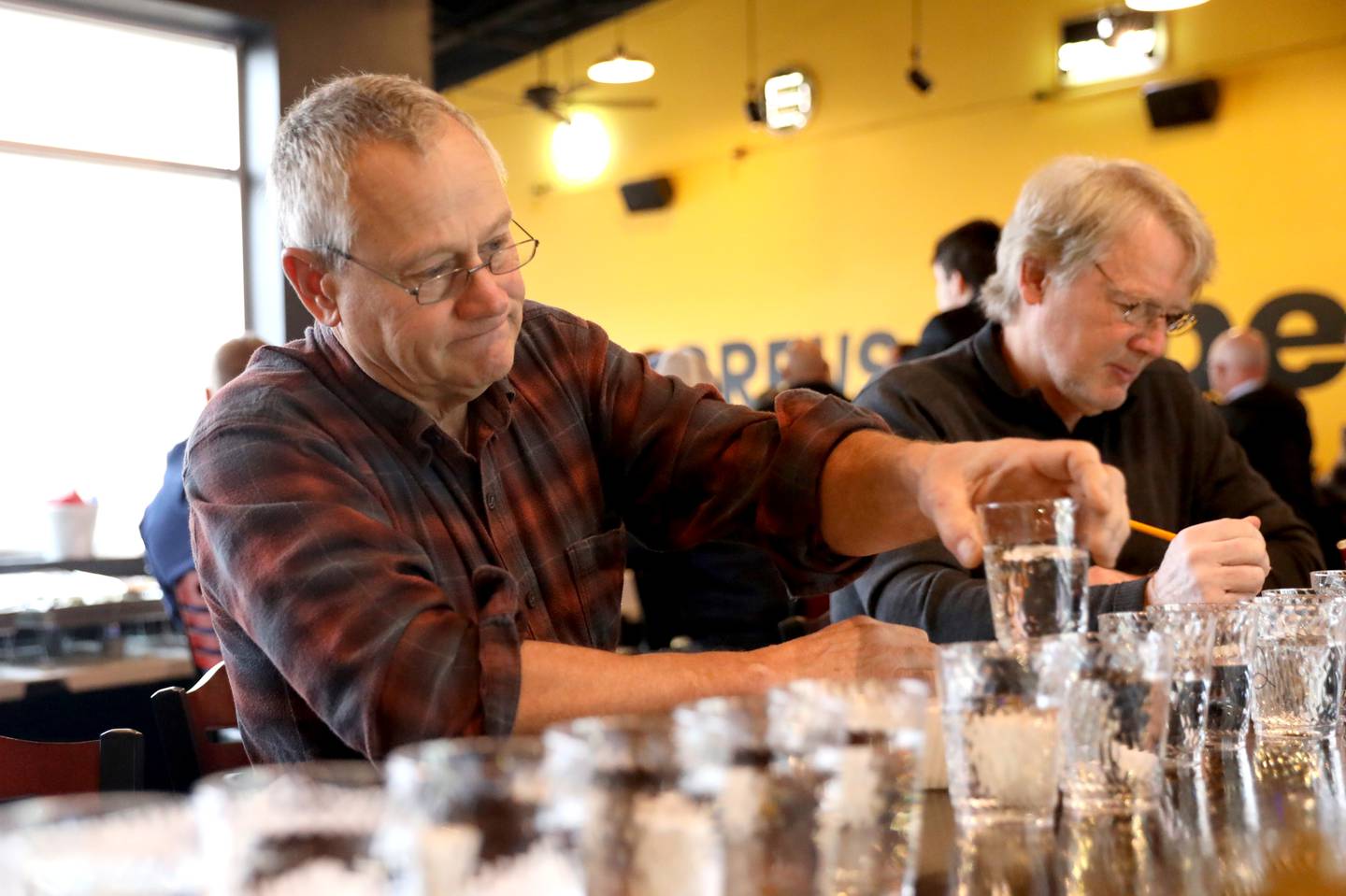 Dan Mann, retired from the Village of South Elgin, tastes water from various villages and cities throughout Kane County during the annual Kane County Water Association Water Taste Test at Global Brew in St. Charles on Thursday, Dec. 15, 2022.