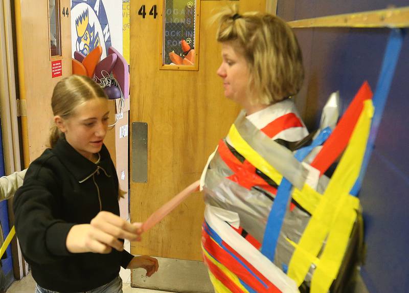 Student Elizabeth Keutzer places a strip of duct tape on physical education teacher Larissa Pinter during the "Tape The Teacher" fundraiser on Friday, March 20, 2026 at Logan Jr. High School in Princeton.