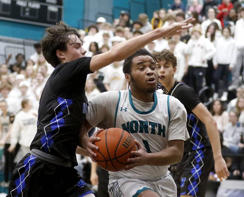Woodstock North's Elijah White drives to the basket against Woodstock's Collin Greenlee during a Kishwaukee River Conference boys basketball game on Friday, Jan. 5. 2024, at Woodstock North High School.