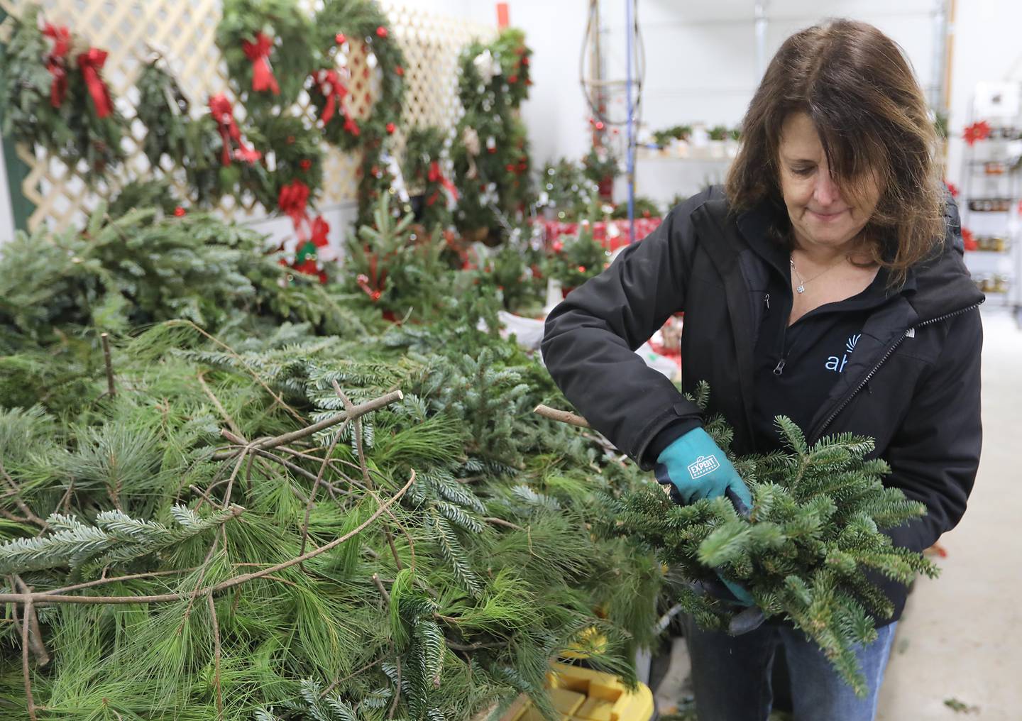 Diana Minalt, of Conifera Tree Farm, makes a wreath at the farm on Tuesday, Nov. 25, 2025, near Harvard.