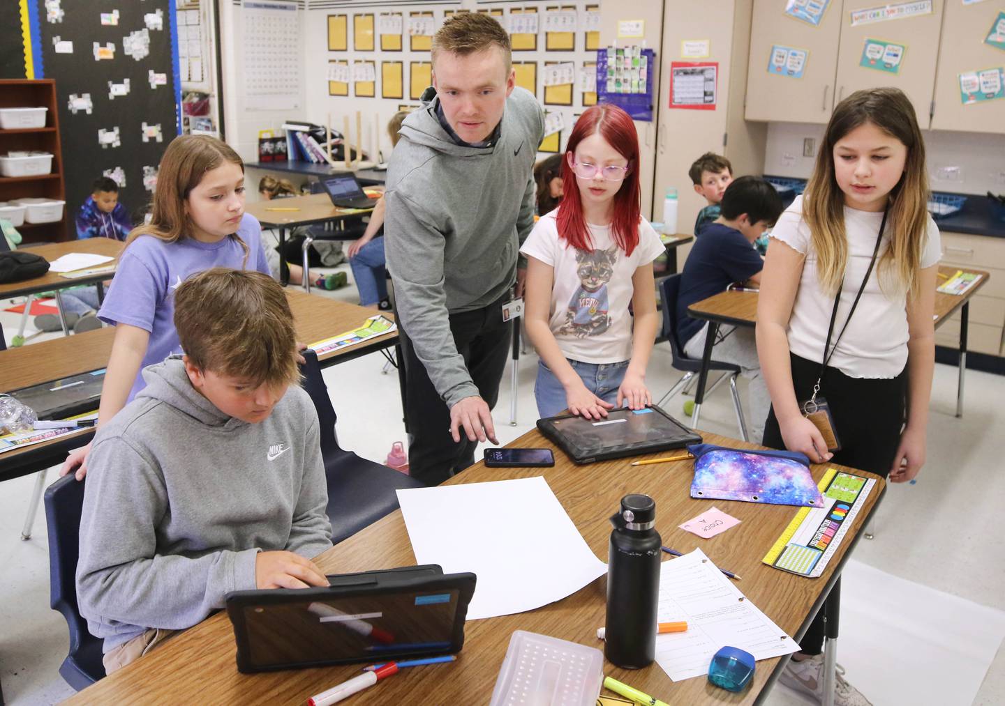 Jacob Winters, fourth grade teacher at South Prairie Elementary School, works with students during a robotics lesson Wednesday, April 6, 2023, at the school in Sycamore.