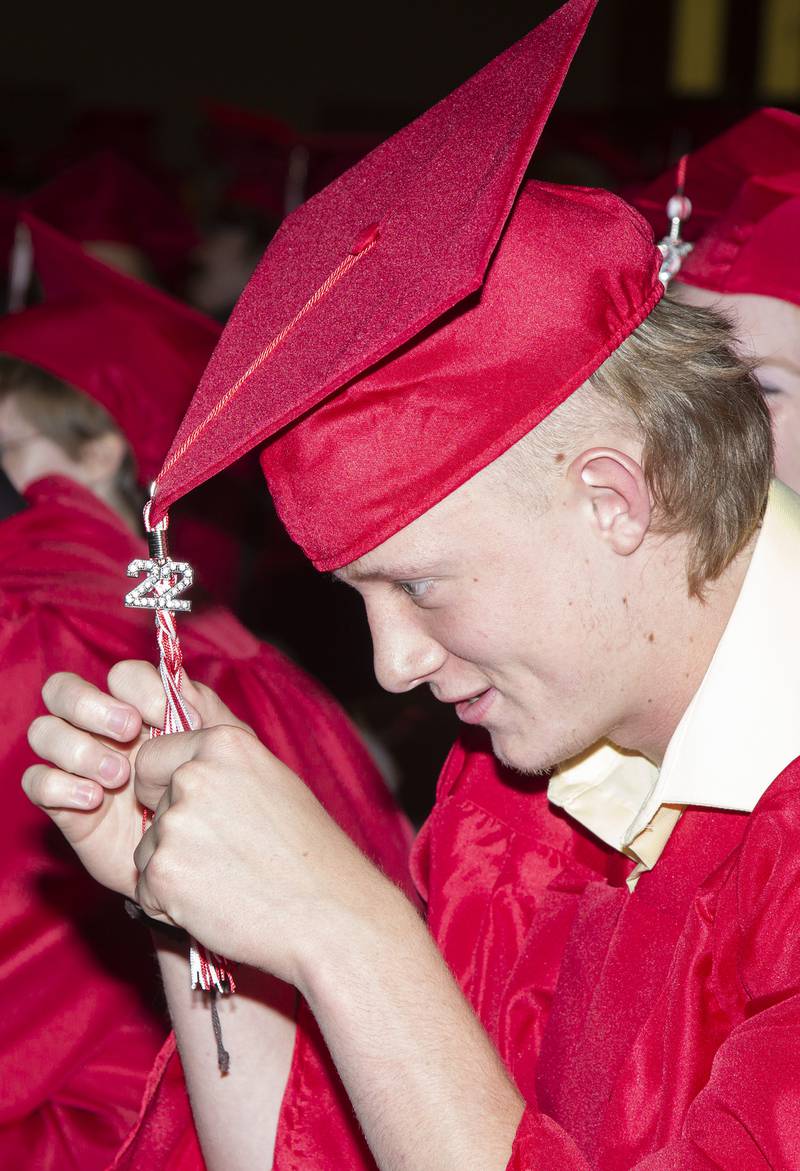 Ottawa High School graduating senior Braiden Miller braids his tassel while waiting in the auditorium Friday, May 27, 2022, for the graduation ceremony to begin.