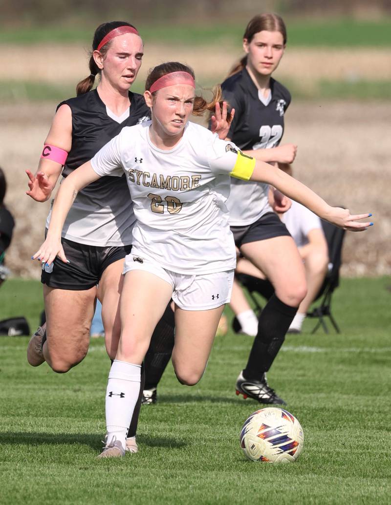 Sycamore's Cortni Kruizenga kicks the ball in front of two Kaneland players during their game Monday, April 13, 2026, at Kaneland High School.