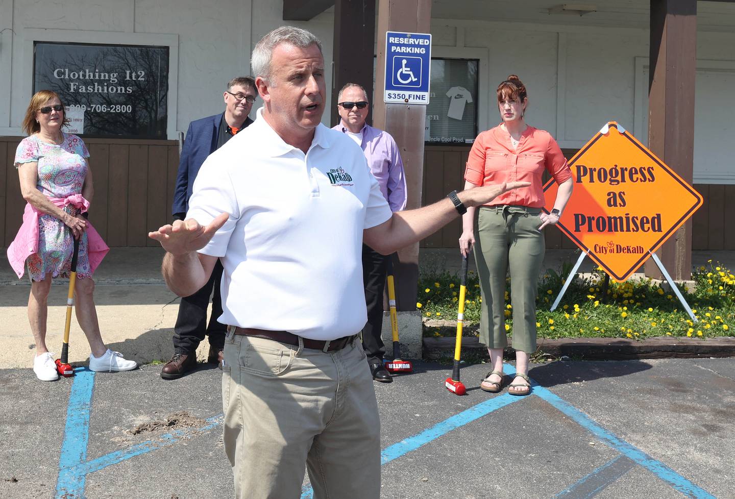 DeKalb Mayor Cohen Barnes, flanked by members of the DeKalb City Council, speaks during a special meeting of the council Monday, May 9, 2022, in the parking lot of the former Hillcrest Shopping Center. The meeting was held to kick off the demolition process of the strip mall on Hillcrest Drive which will begin Tuesday morning.