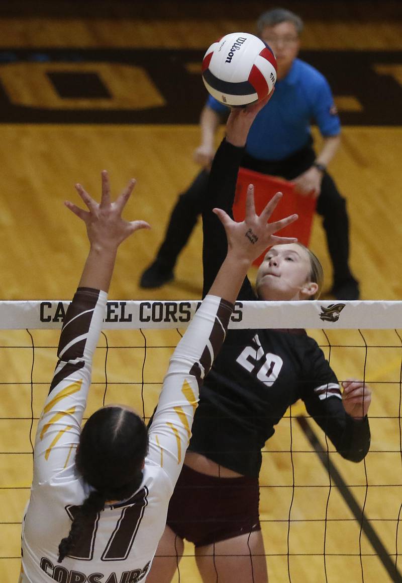 Prairie Ridge's Ava Bell (right) hits the ball over the block of Carmel’s Charlotte Shepherd during the IHSA Class 3A Carmel Sectional championship volleyball match on Thursday, Nov. 6, 2025, at Carmel High School, in Mundelein.