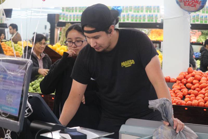 Jocelyn Vehena (left) and Martin Garcia work the register at DeKalb Fresh Market, 304 N. Sixth St., DeKalb, on Tuesday, Nov. 21, 2023.