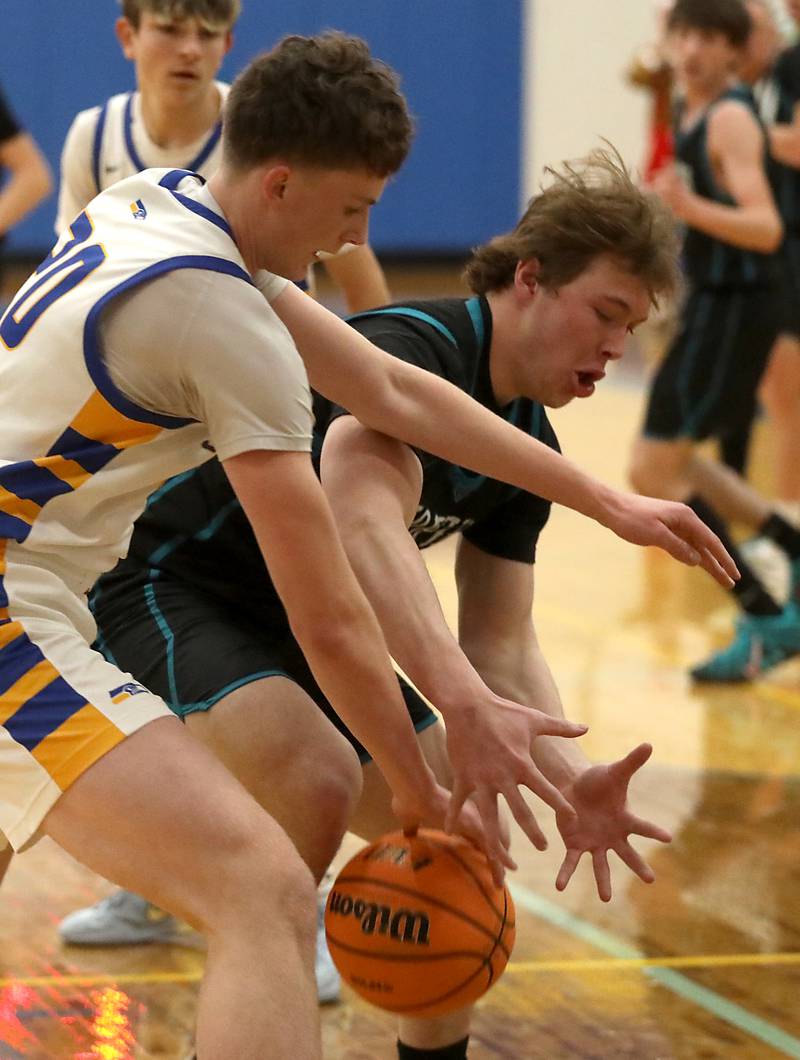 Johnsburg's Josh Kaunas battles with Woodstock North's Brady Rogers for a rebound during a Kishwaukee River Conference boys basketball game on Monday, Dec. 15, 2025, at Johnsburg High School.