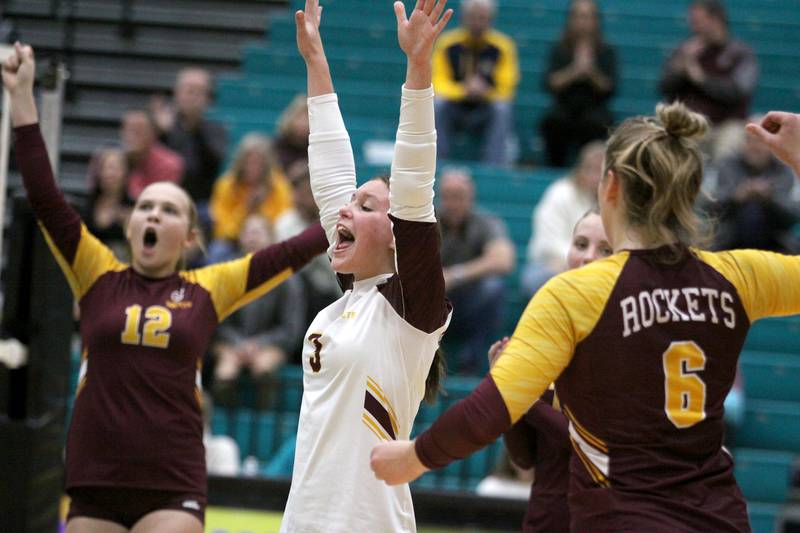Richmond Burton’s Delanee Cooley, center, Zoe Freund, left, and Elissa Furlan, right, rejoice as they build an early lead in the second set of a two-set-conference-clinching win in varsity volleyball action at Woodstock North High School in Woodstock on Wednesday, Oct. 16, 2024.