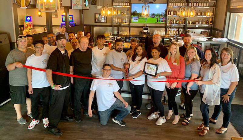 Nikunj and Dhara Patel cut the ribbon to celebrate the Grand Opening of their third McHenry County restaurant and bar, Lucky Lucy's 7.  They are joined by their friends, family and staff, along with the staff and board members of the Cary-Grove Area Chamber of Commerce.