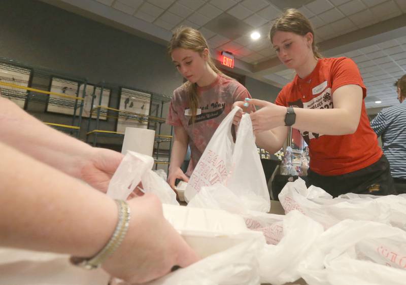 Lilly Breckenridge and her sister Candace, fill to-go containers during the Lighted Way spaghetti dinner on Monday, April 28, 2025 at Uptown Bar & Grill downtown La Salle.