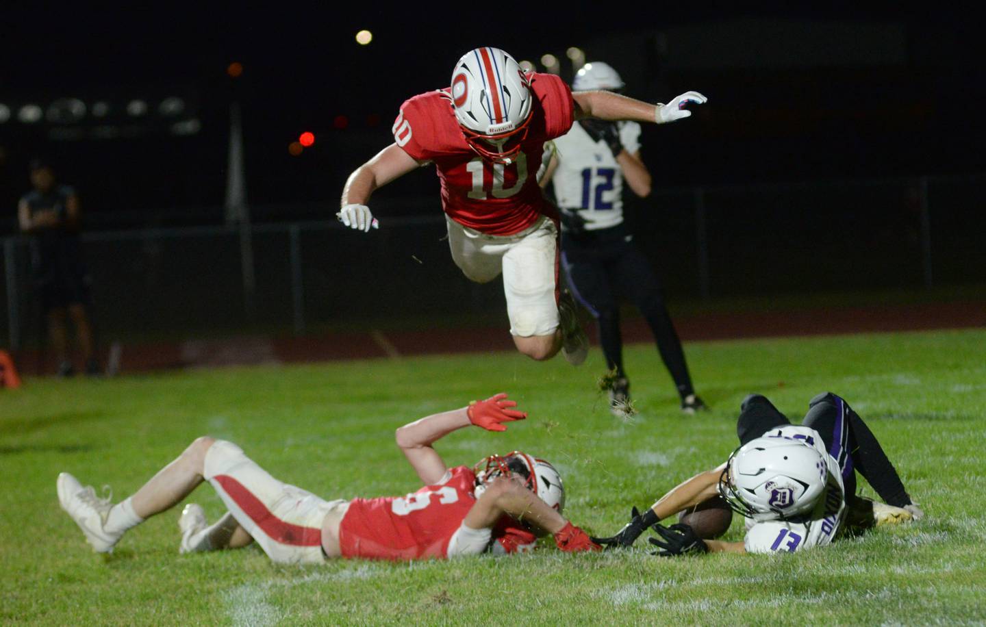 Oregon's Keaton Salsbury (10) jumps over Oregon's Landon Ziller (6) and Dixon's Kellen Haenitsch (13) after a Dixon pass was incomplete in the end zone on Friday, Sept. 26, 2025 at Landers-Loomis Field in Oregon.