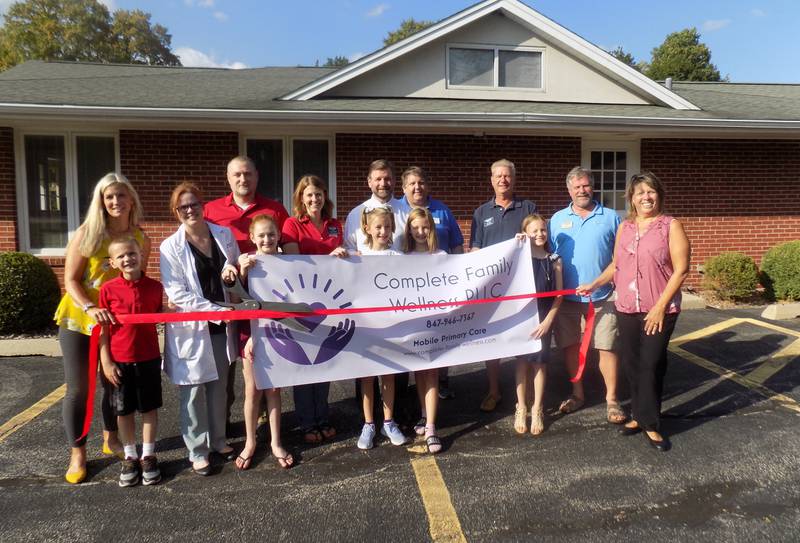 Helen Muchow FNP-BC, APRN, MSN , owner of Complete Family Wellness, along with her husband Matt, their children, and the staff and board members of the Cary-Grove Grove Area Chamber of Commerce, celebrate the grand opening of  Complete Family Wellness, LLC, a mobile healthcare practice.