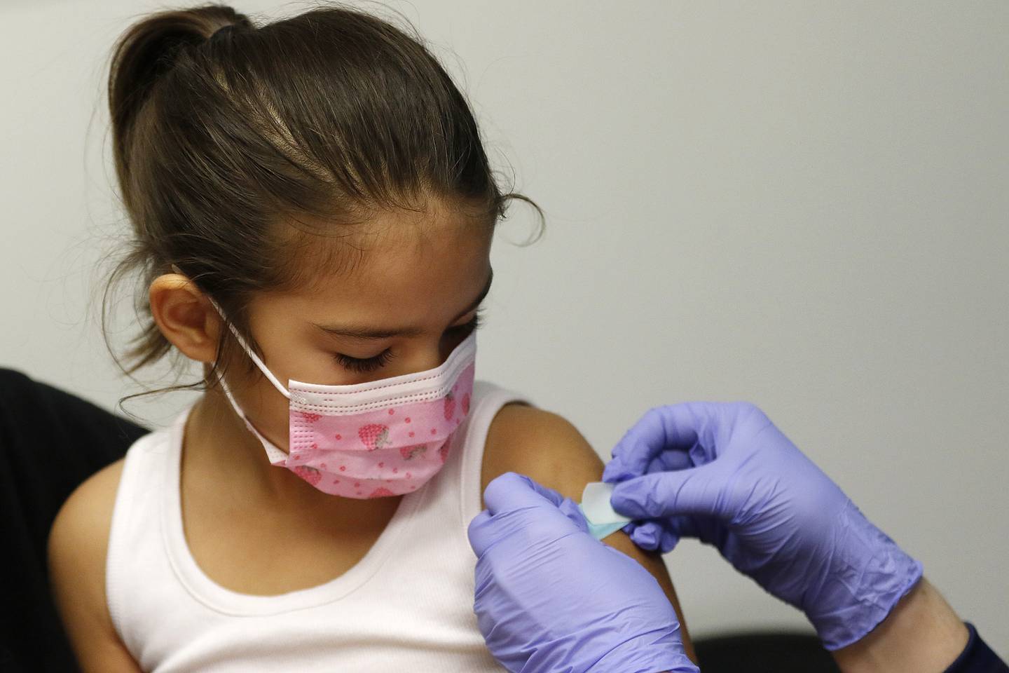 Eden Gomez, 5, of Carpentersville, watches as nurse Maggie Juarez applies a bandage over her first dose of the Pfizer vaccine on Friday, Dec. 3, 2021, at Advocate Children's Medical Group in Crystal Lake.  Children ages 5 to 11 are now eligible for COVID-19 vaccines.
