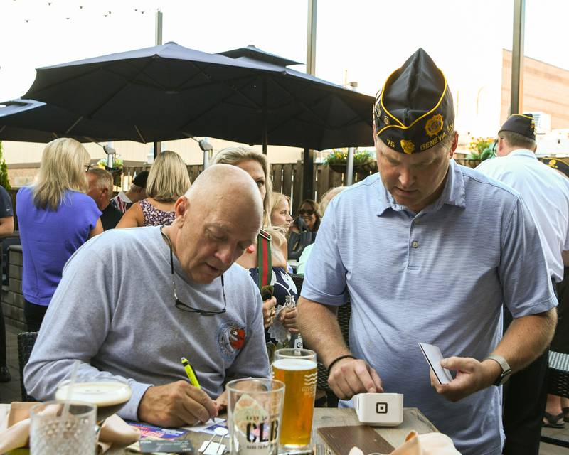 Kevin Augle of St. Charles fills out a raffle ticket as Bryan Fuller of the Geneva American Legion processes the 50/50 on Thursday Aug. 21, 2025, held at Whiskey Bend in St. Charles.