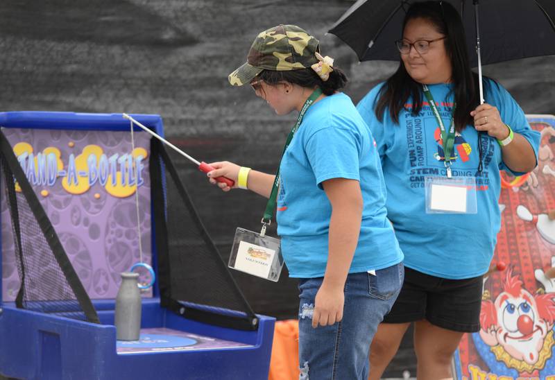 Volunteer of the Downers Grove Octoberfest, Amberley Siguencia of Melrose Park tries the game she's assisting with beside her mom Delmy Pacheco Saturday, Sept. 16, 2023.