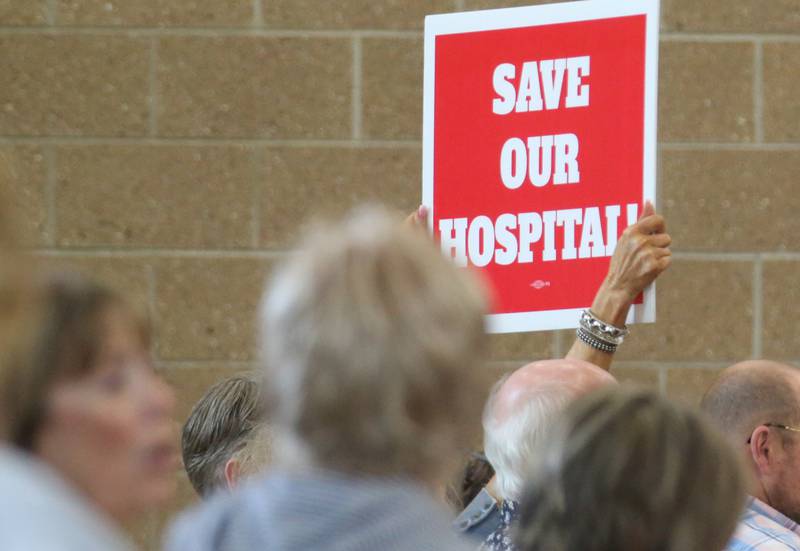 A crowd member holds a sign that reads "Save Our Hospital"  during a public hearing regarding OSF St. Elizabeth Hospital's plans to reduce services on Tuesday, June 10, at Central Intermediate School in Ottawa.