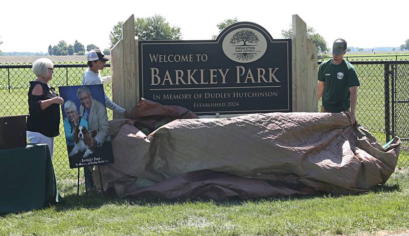 Tammie Lange executive director at Princeton Park District and Princeton Park District employees Carlos Benavidez and Caden Wahlgren unveil a new dog park on Thursday, May 23, 2024 at Zearing Park in Princeton. The one acre park has duel sections for small and large dogs, benches, a dog water fountain and waste station. Jeanne Hutchinson has donated the funds to the Princeton Park District to fund the building of the dog park and to generate income to help maintain its care.