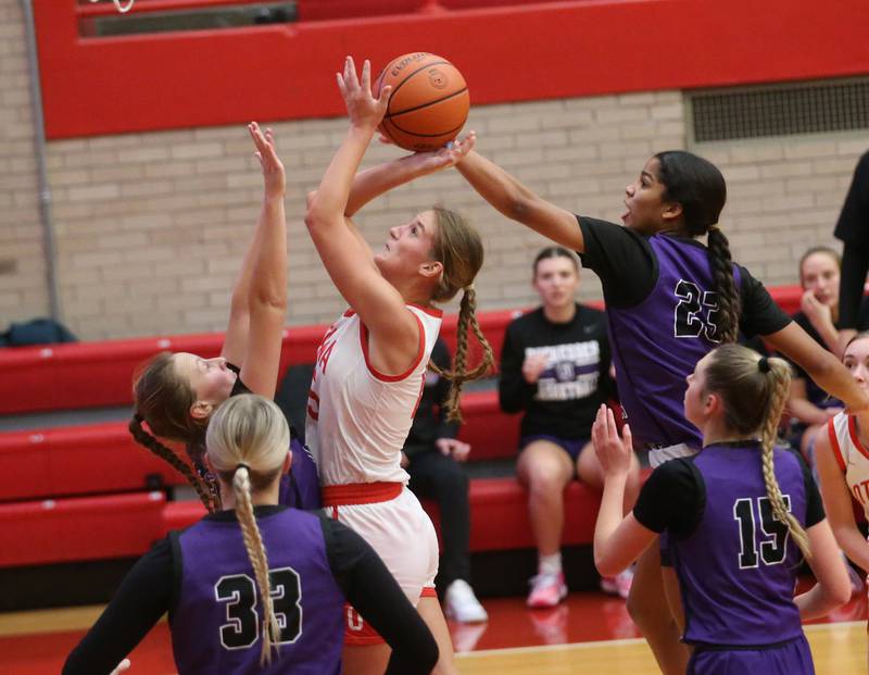 Ottawa's Hailey Larsen pulls up in the lane to shoot a basket over Dixon's Katie Drew and teammate Ahmyrie McGowan on Wednesday, Nov. 29, 2023 at Kingman Gym.