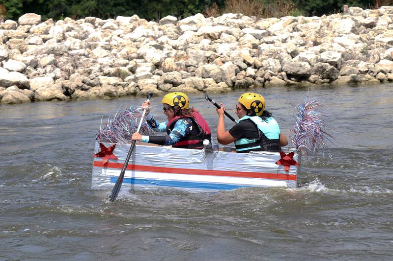 Participants of the cardboard boat race paddle down the Fox River at Yorkville River Fest on Saturday, July 19, 2025.