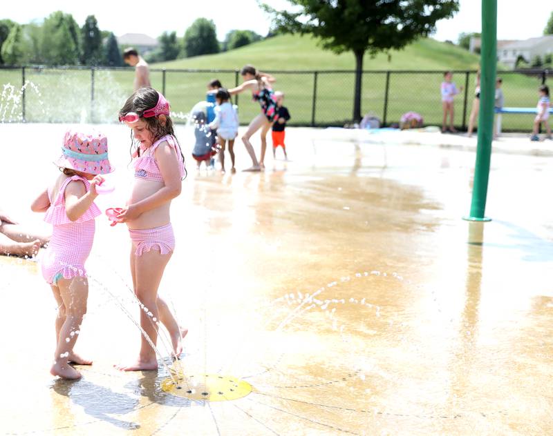 Sisters Hannah, 2, and Charlotte Duey, 4, stay cool at the Oswegoland Park District's Prairie Point Splash Pad on Wednesday, June 25, 2025 in Oswego.