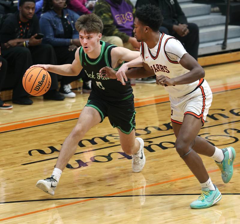 Rock Falls' Max Burns tries to get by DeKalb's Derrion Straughter during their game Tuesday, Dec. 2, 2025, at DeKalb High School.