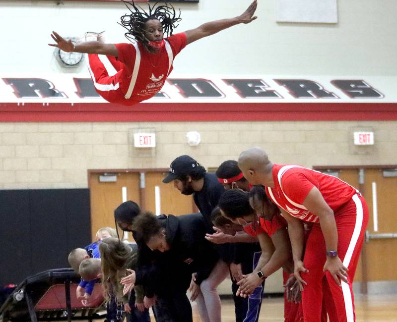 Andre Williams of the Jesse White Tumblers soars over 12 teammates and audience members during the Black History Month event, titled “Celebrating Black Stories: Narratives on Identity, Belonging and Community,” which was held Feb. 24, 2022, at Huntley High School.