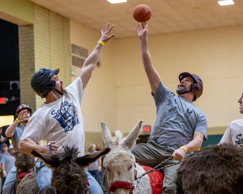 Member of the 'Village Church' team shoots midrange shot over member of 'Seneca FFA Officers and Alumni' in game of Donkey Basketball on Saturday, Feb. 7, 2026 at Seneca High School West Campus in Seneca.