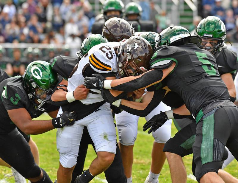Joliet Catholic’s Anthony Finnegan (25) runs into a wall of Glenbard West defenders including Jayden Daniel (3) and Max Hetlet (5) during a game on September 6, 2025 at Glenbard West High School in Glen Ellyn.