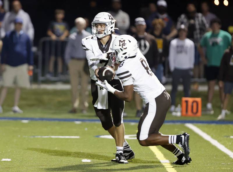 Mt. Carmel's Nathan Sanders (8) takes a handoff from (7) Emmett Dowling during the varsity football game between Mt. Carmel high school and Nazareth Academy on Friday, Sept. 12, 2025 in La Grange Park, IL.