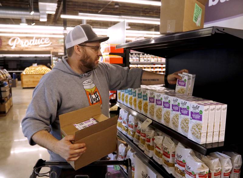 Patrick Neily with National Co+op Grocers, stocks items at the Food Shed, McHenry County's first co-op grocery store, on Friday, May 10, 2024, as the store prepares to open on May 15.