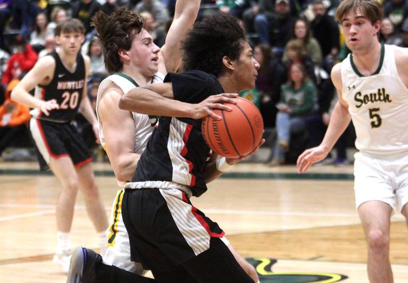Crystal Lake South’s Cooper LePage, center back, guards Huntley’s Omare Segarra in varsity boys basketball at Crystal Lake Friday night.
