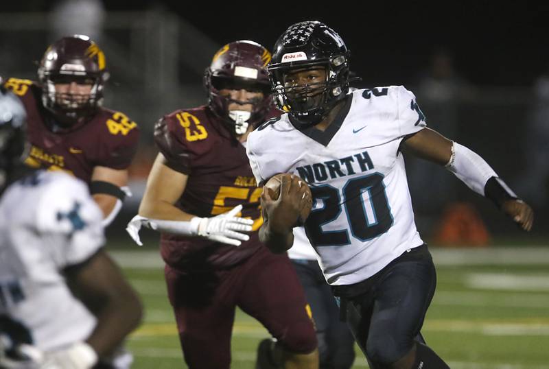Woodstock North's David Randecker runs with the ball as he is chased by Richmond-Burton's Logan Garcia during a Kishwaukee River Conference football game on Friday, Oct. 11, 2024, at Richmond-Burton High School.