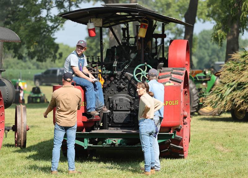 Danny Cork, (seated left) from Burlington, displays his 1917 20 horsepower Minneapolis steam-powered tractor during the Sycamore Steam Show Thursday, Aug. 10, 2023, at Taylor Marshall Farm in Sycamore. The show runs from 7 a.m. to 5 p.m. through Sunday.